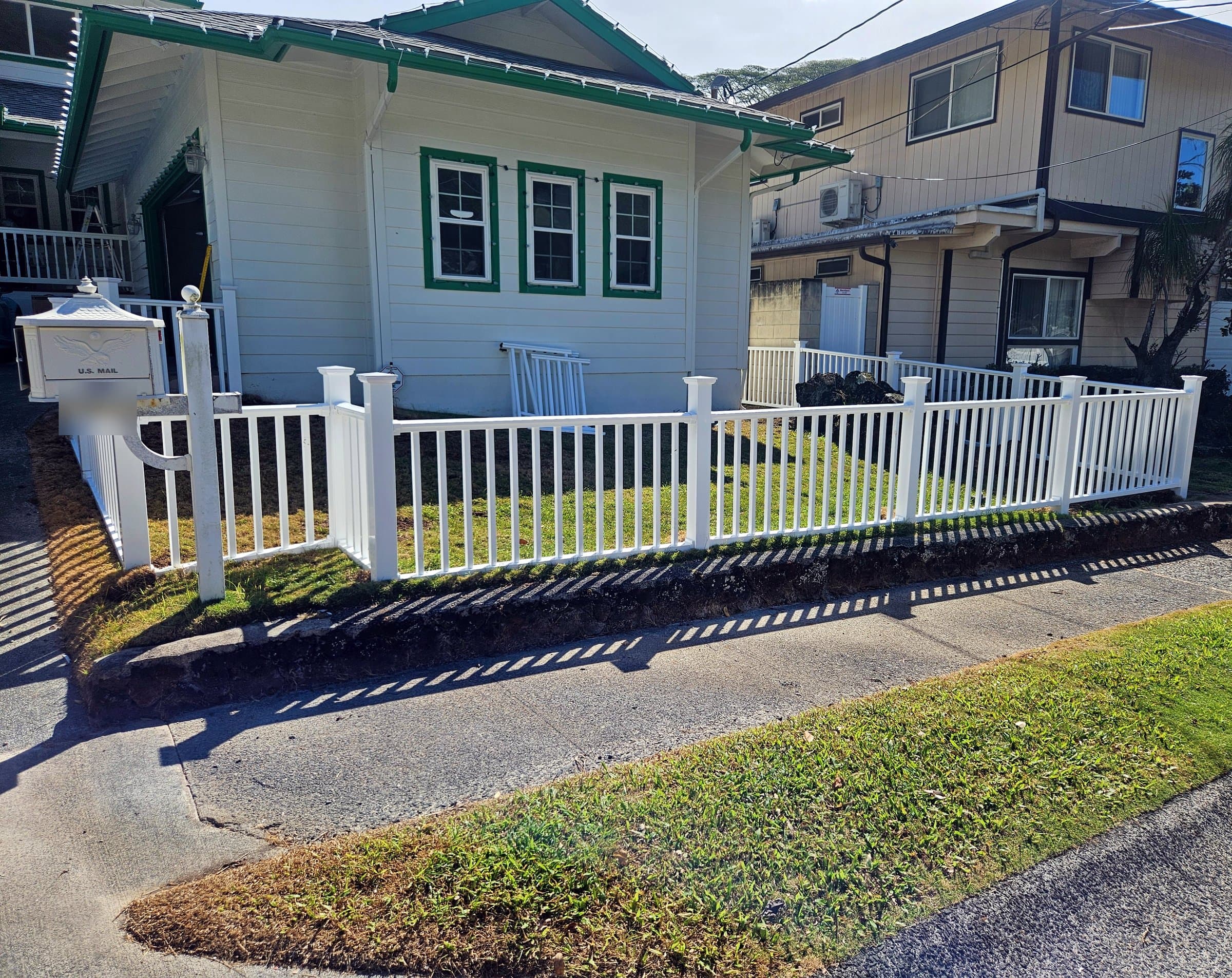 White vinyl picket fence along a front yard